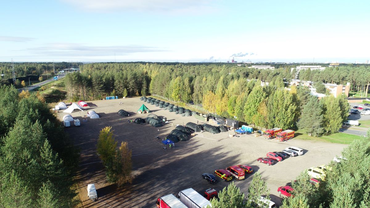 Kuvassa monikansallinen tukikohta hiekkakentällä, Base Camp Oulussa. Teltat on pystytetty järjestelmällisesti hiekkakentälle. 